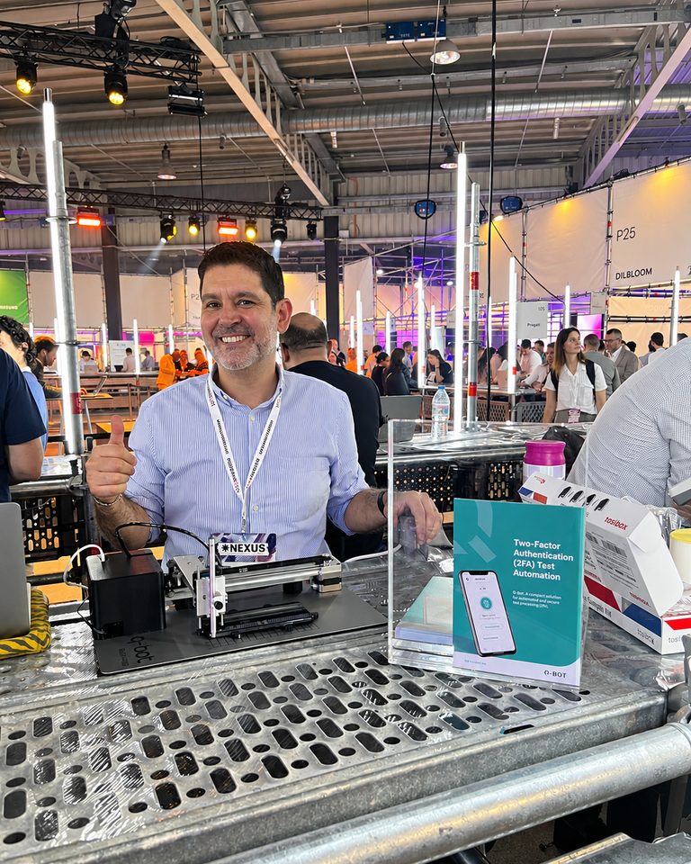 Sylvain Perez sur le stand Q-Bot d'un salon professionnel, le boîtier posé devant lui